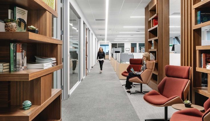 an office filled with lots of wooden shelves and chairs next to each other on either side of the room