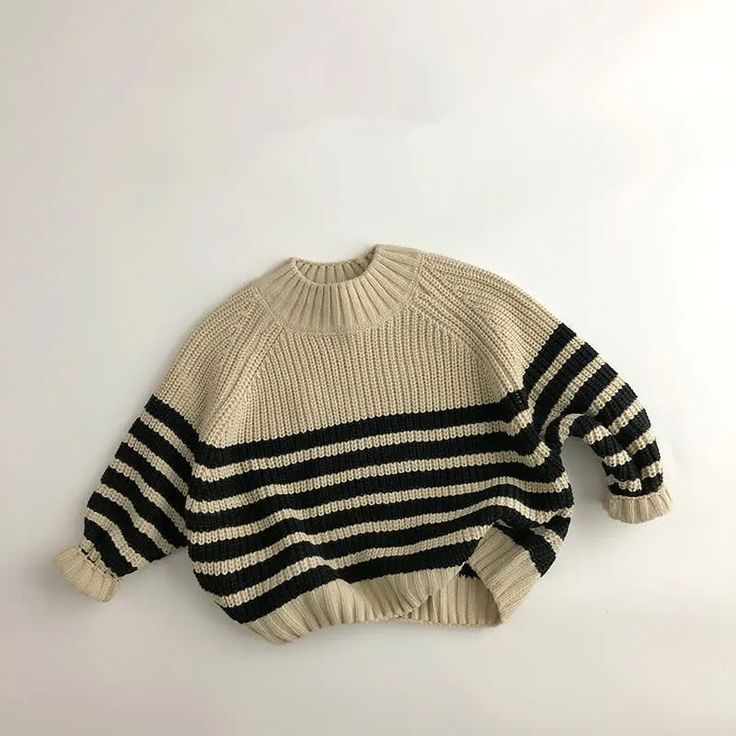 a black and white striped sweater hanging on a wall