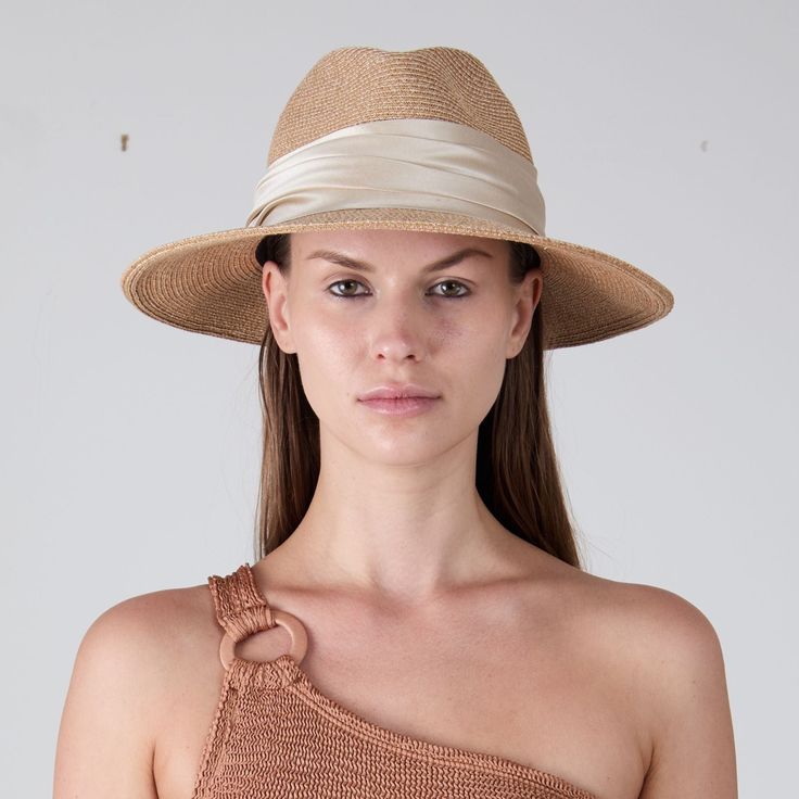 Sand toyo packable UPF 25+ protection fedora with cream shiny satin ruched band. UPF 25+ protection. Measurements: 6" X 3.75" X 3" SKU: 21005-250CS Elegant Beige Straw Hat For Travel, Elegant Cream Travel Hat, Cream Fedora Sun Hat For Kentucky Derby, Cream Fedora Panama Hat For Kentucky Derby, Elegant Fedora With Upf 50+ For Travel, Beige Short Brim Fedora For Kentucky Derby, Kentucky Derby Cream Fedora Sun Hat, Chic Fitted Beige Panama Hat, Chic Beige Fitted Panama Hat