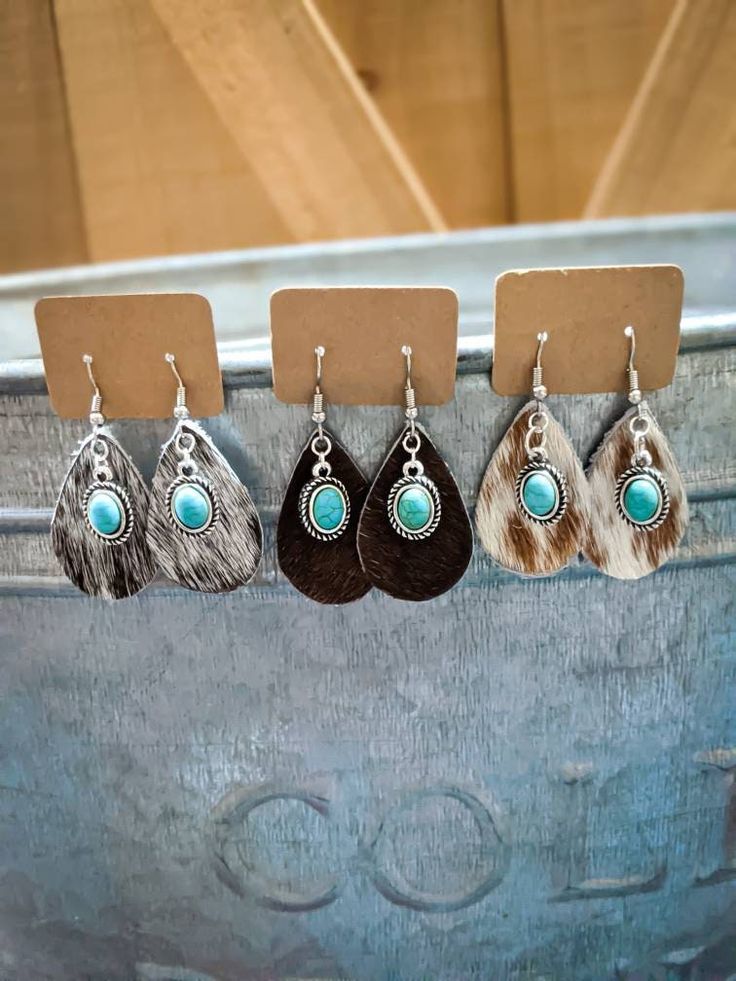 Cowhide & turquoise earrings, cowhide earrings, cowhide turquoise, cowhide jewelry, turquoise jewelry, western jewelry, cowgirl jewelry You are going to love our tear drop cowhide earrings with a little turquoise!! These are 3.5 cm long. These are also a perfect match for any of the cowhide sandals in my shop! The earrings shown in the photos are the previous earrings I have made. PLEASE NOTE you will NOT receive the exact color pattern in the picture. This is REAL cowhide and the markings a Cow Hide Earrings, Cowhide Earrings Handmade, Cowhide Sandals, Cowhide Jewelry, Cowhide Earrings, Cowboy Cactus, Turquoise Jewelry Western, Southern Jewelry, Rodeo Jewelry