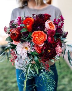 a woman holding a bouquet of flowers in her hands