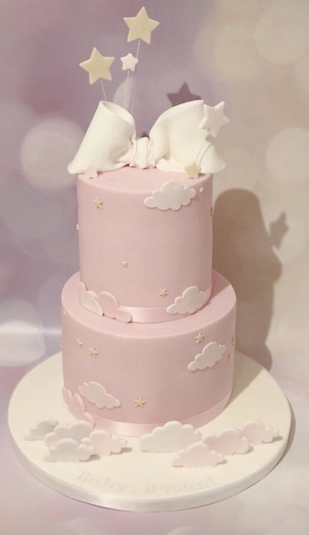 a pink cake with stars and clouds on top