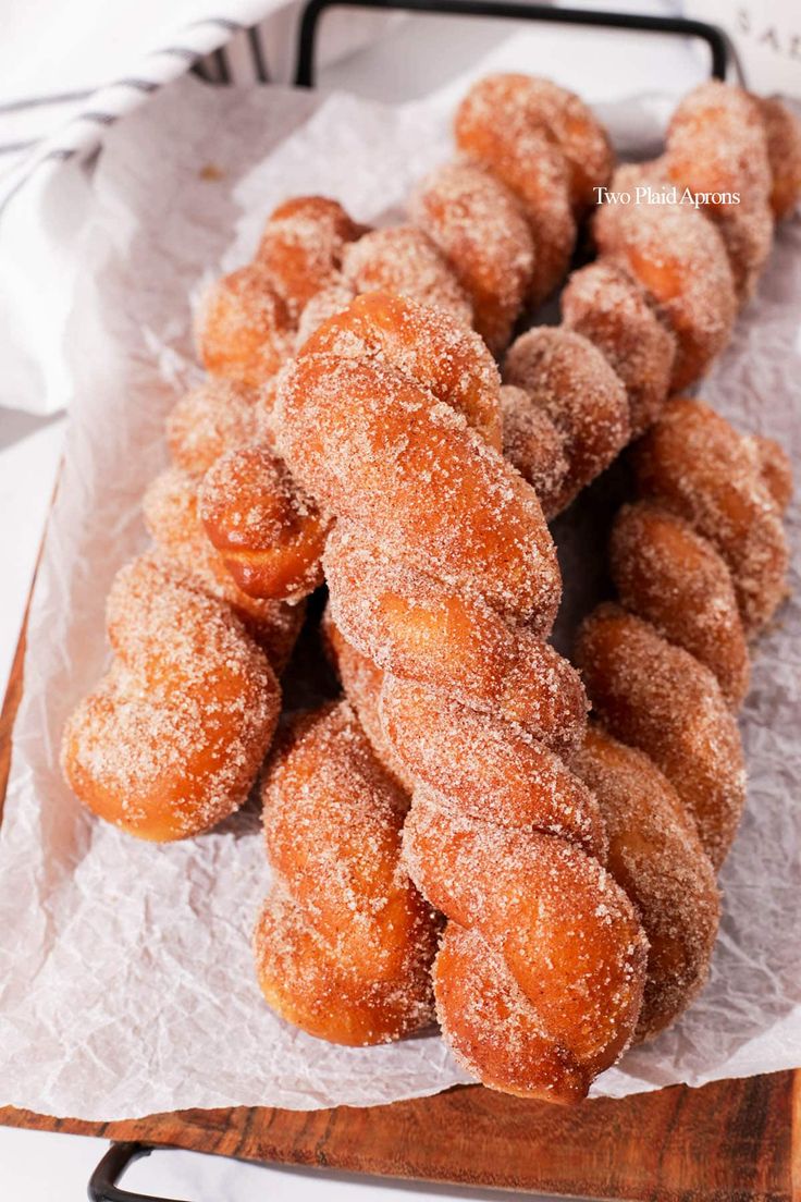 several sugar covered donuts sitting on top of a wooden tray next to each other