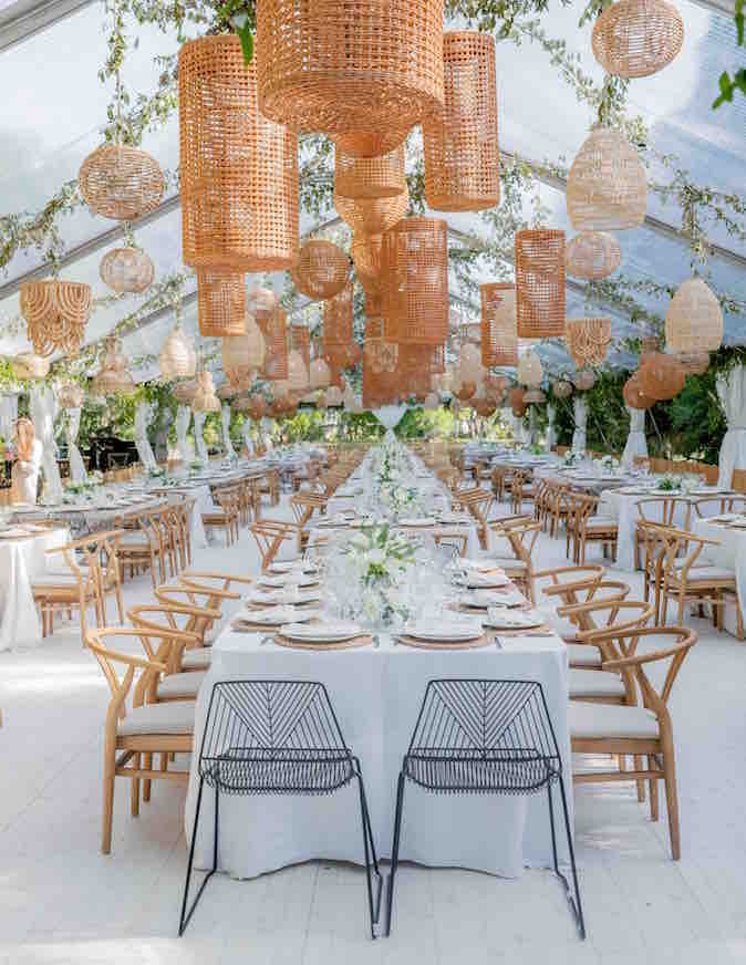 an outdoor tent with tables, chairs and hanging lights