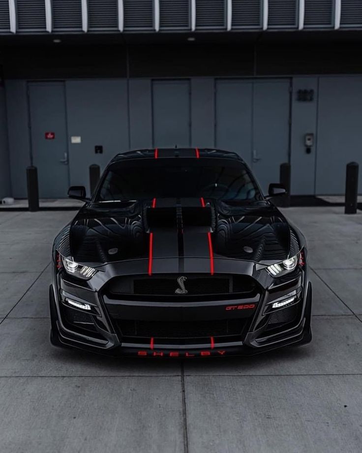 the front end of a black car with red stripes