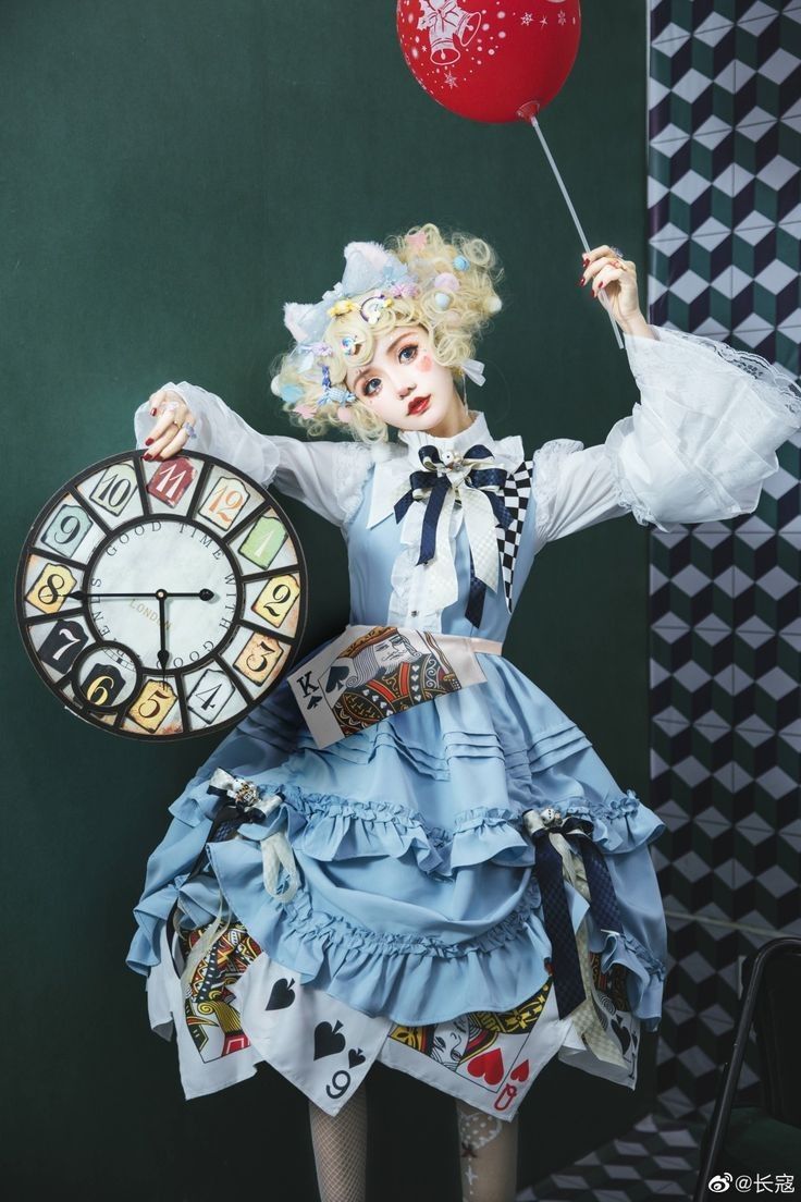 a woman dressed as a clown holding a clock and balloon in front of her face