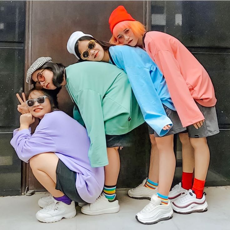 four young women posing for the camera in front of a door with their fingers up