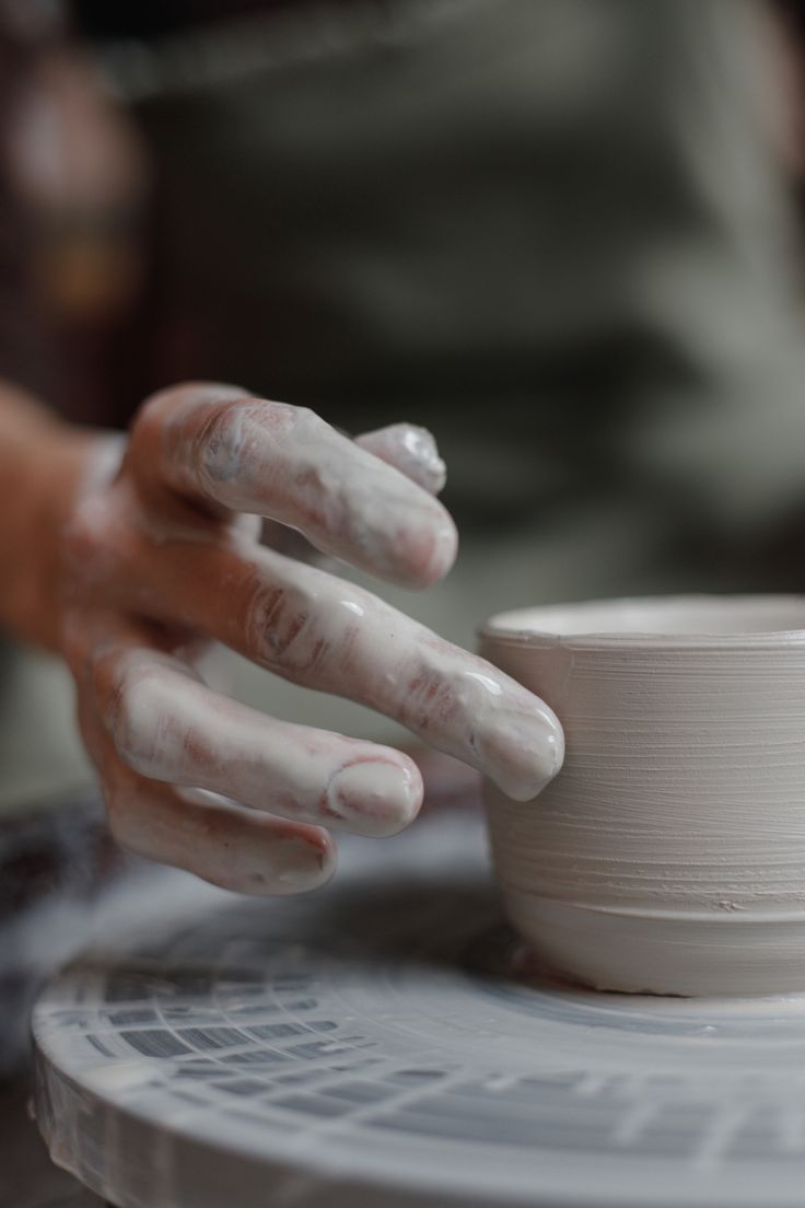 a person's hands are touching a white bowl