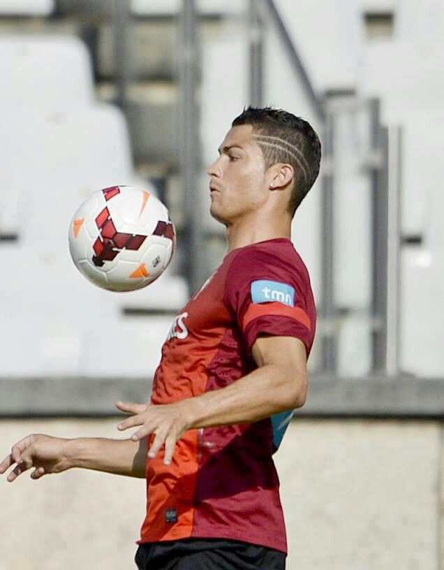 a man in red shirt playing with a soccer ball