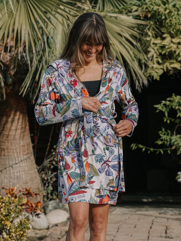 Our new Sun Robe is as at home as a poolside cover-up as it is in your hotel room. It’s light-packing and multi-tasking! Keep the sun off with our vibrant prints in a soft and luxurious UPF 50 poly spandex blend fabric, or have a leisurely breakfast on the front veranda in style. The Sun Robe makes a great gift idea for a home or holiday! Content: 95% polyester 5% spandex + Two Front Pockets+ Oversized Hood+ Waist Tie Spring Printed Loungewear Cover-up, Printed White Vacation Sleepwear, Printed White Sleepwear For Vacation, White Printed Sleepwear For Vacation, Tropical Summer Sleepwear For Loungewear, Summer Sleepwear For Lounging During Beach Season, Summer Multicolor Sleepwear For Vacation, Summer Floral Print Sleepwear For Vacation, Summer Sleepwear With Floral Print For Vacation