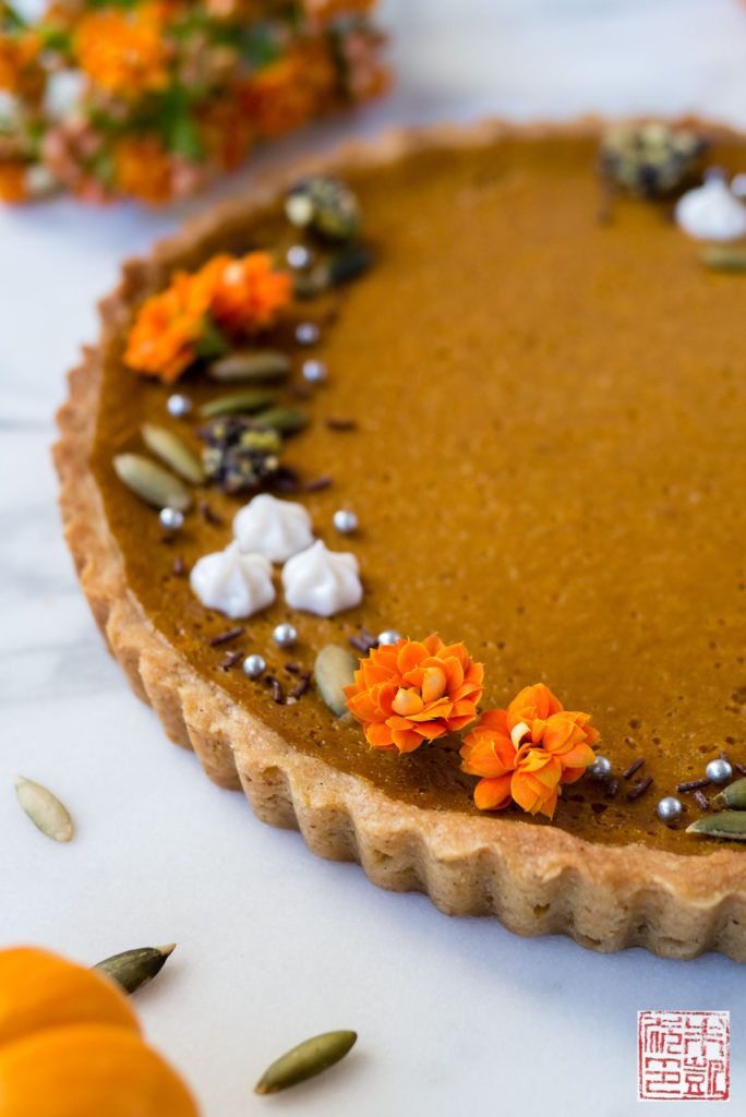 a pumpkin pie is decorated with flowers and seeds