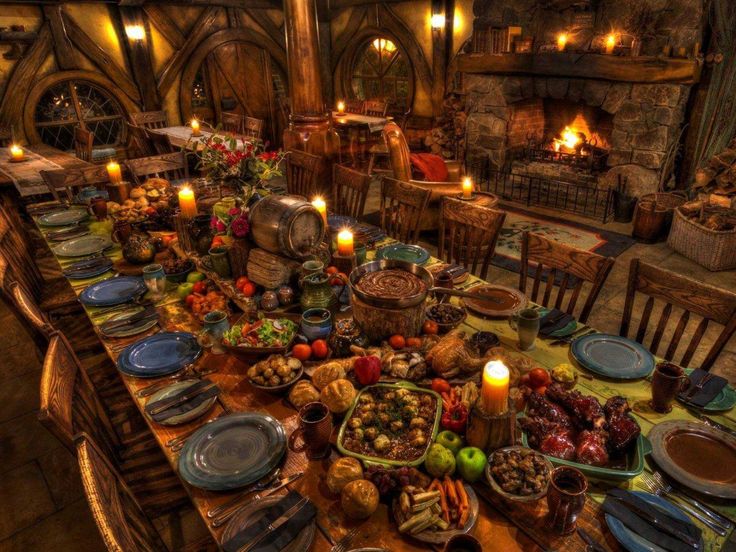 a dining room table is set with food and candles