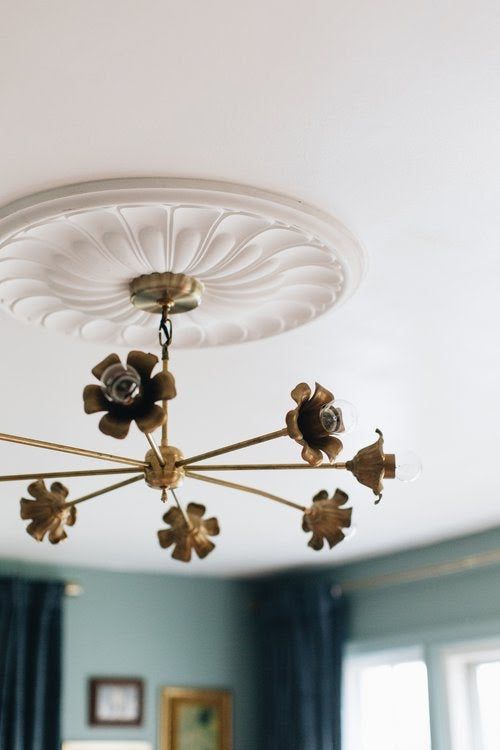 a chandelier hanging from the ceiling in a room with blue walls and curtains