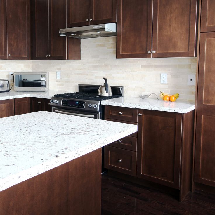 a kitchen with brown cabinets and white counter tops