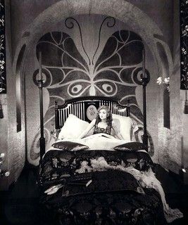 a woman laying on top of a bed in a bedroom