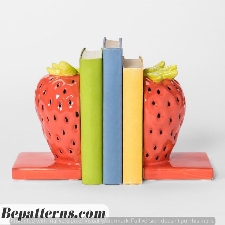 a bookend made out of two books with a strawberry on one and a blue book on the other