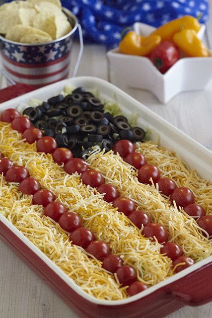 an american flag shaped food dish with olives and tomatoes