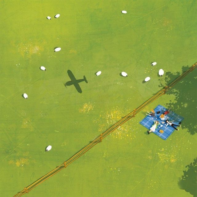 an aerial view of a plane flying over a field with sheep in the grass and trees