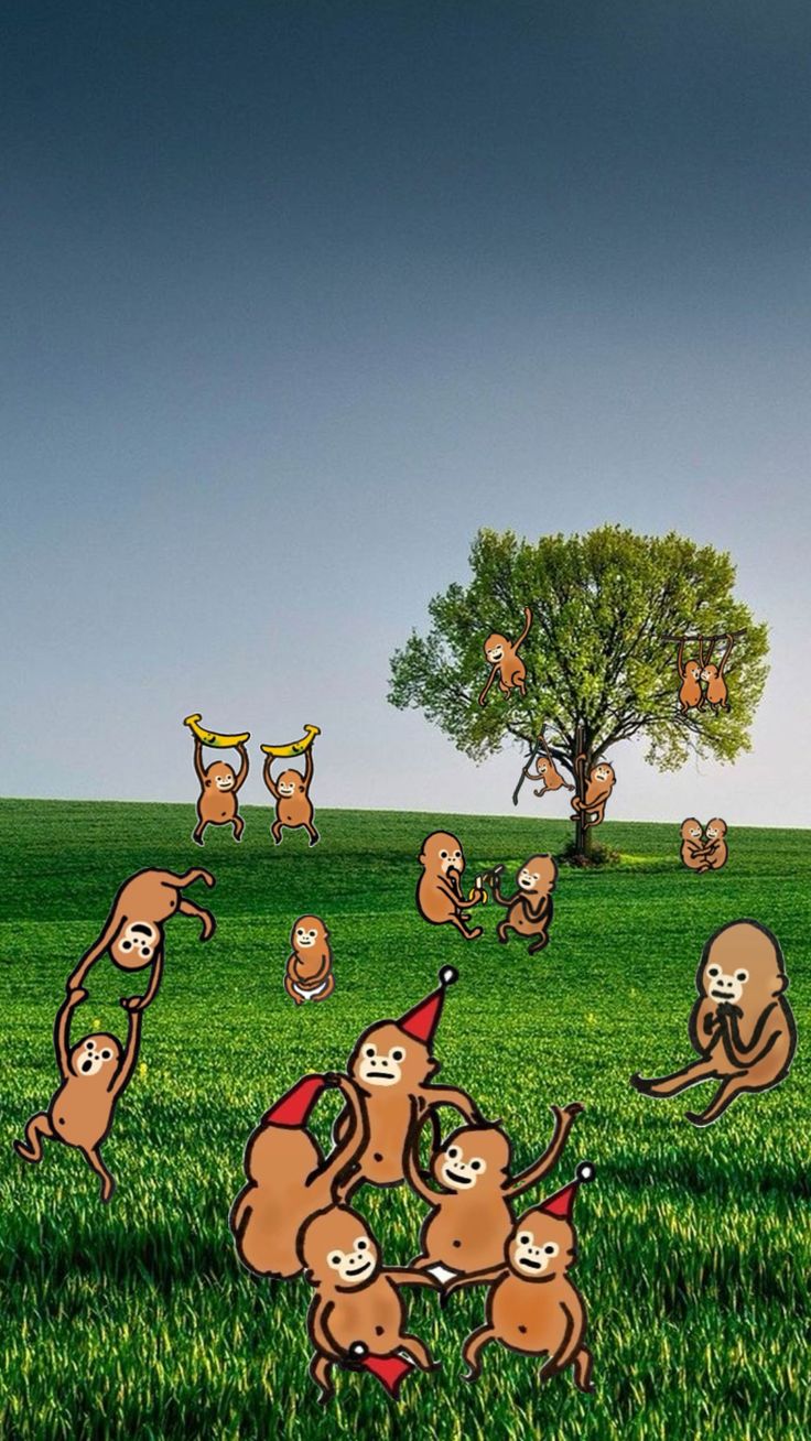 a group of monkeys playing with each other in the grass next to a tree and flying kites