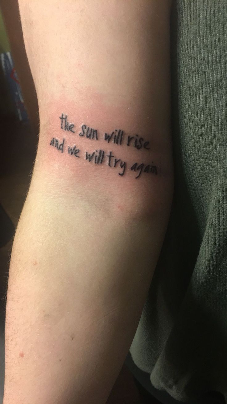 the sun will rise and we will try again on someone's arm with an ink quote