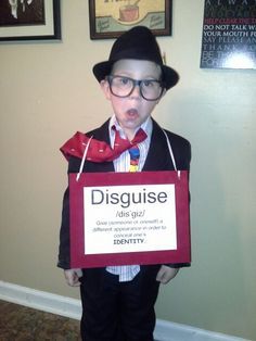 a young boy dressed as a magician holding a sign that says disgulie