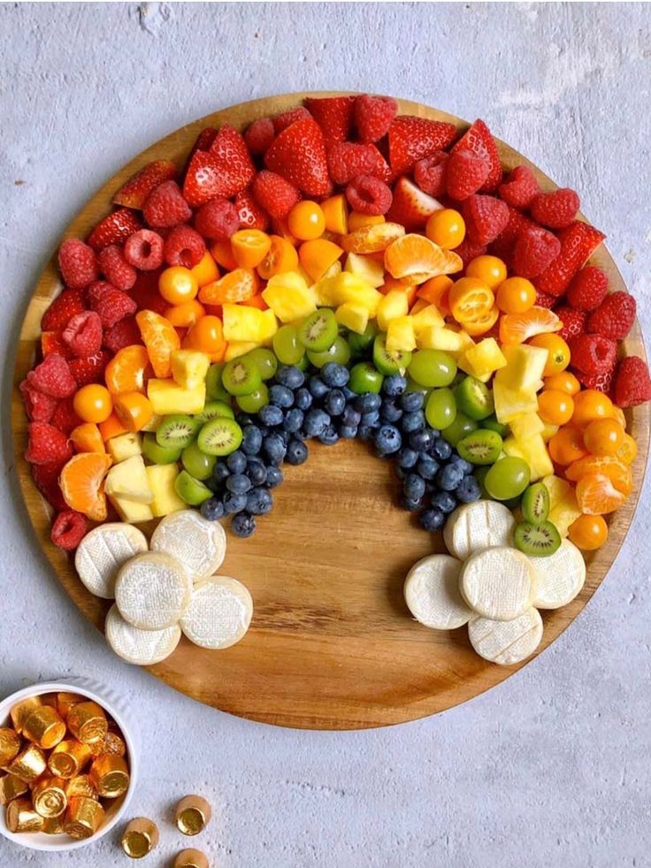 a wooden plate topped with fruits and vegetables