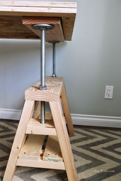 a small wooden table with a metal base on it's legs and a wood top