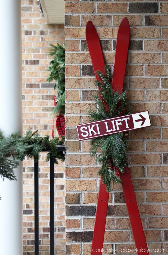 a ski lift sign mounted to the side of a brick building with wreaths on it