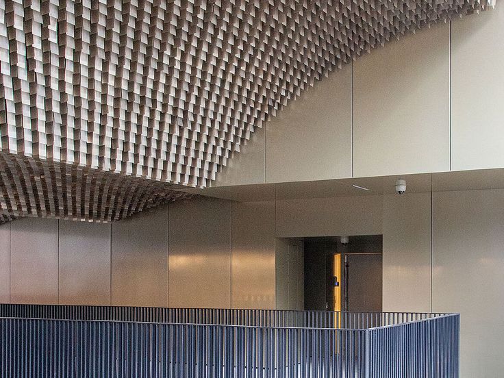 the interior of an office building with blue walls and metal partitions on the ceiling