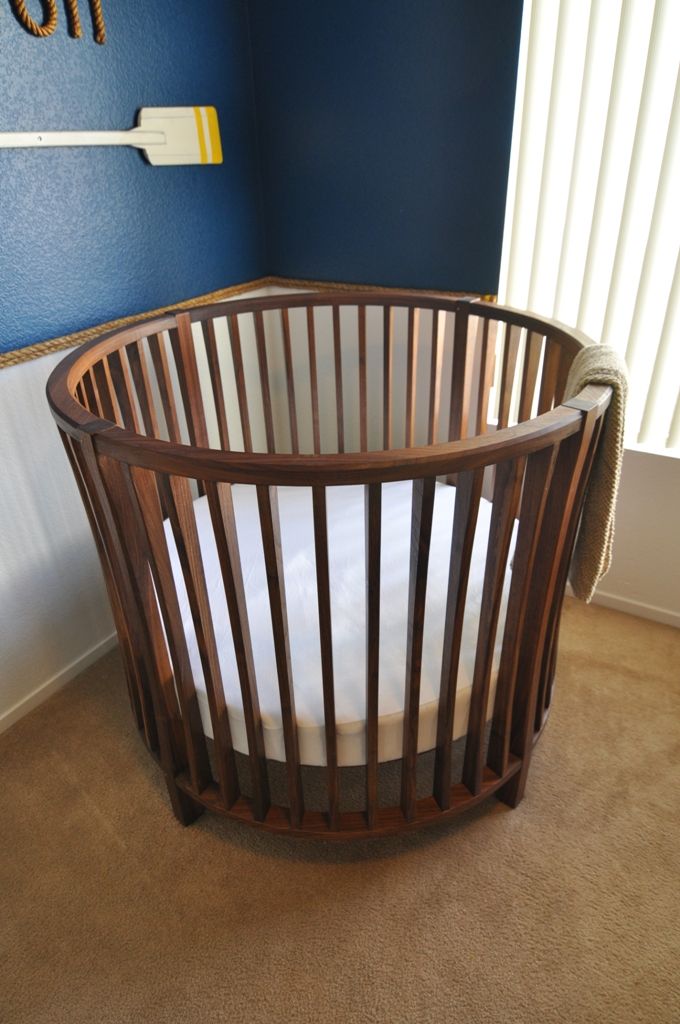 a baby crib in the corner of a room with blue walls and tan carpet