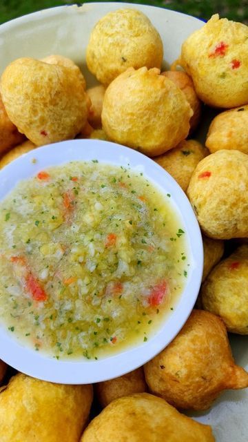 a white bowl filled with food next to muffins on top of a table