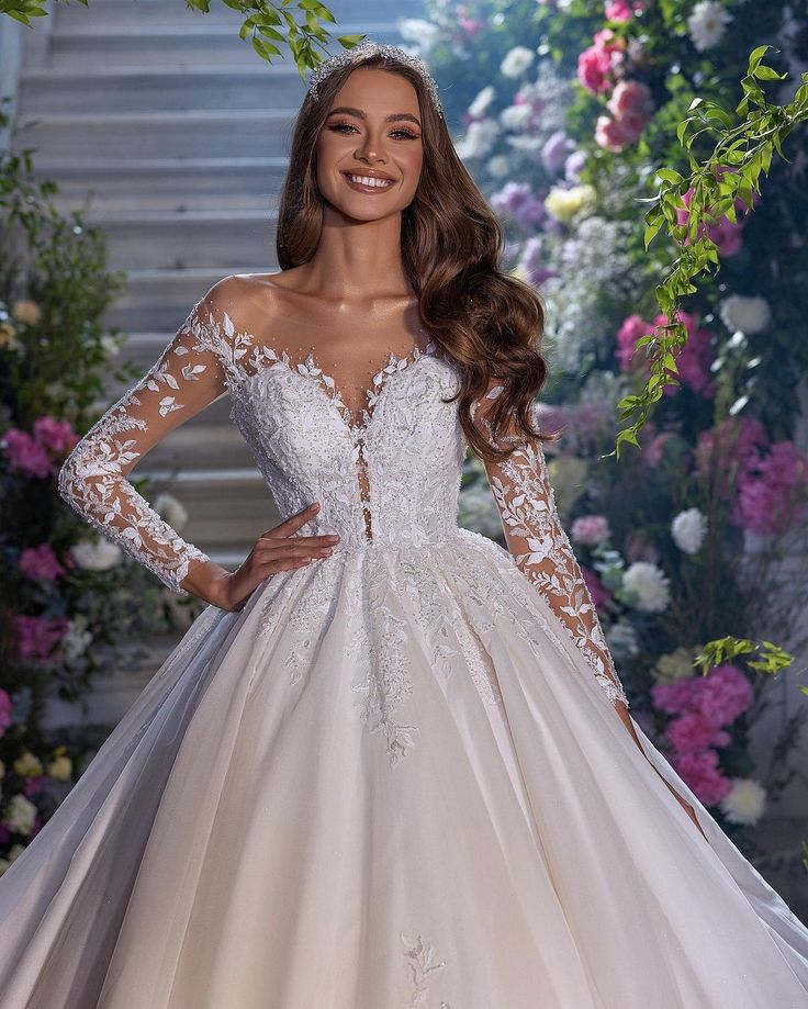 a woman wearing a wedding dress with long sleeves