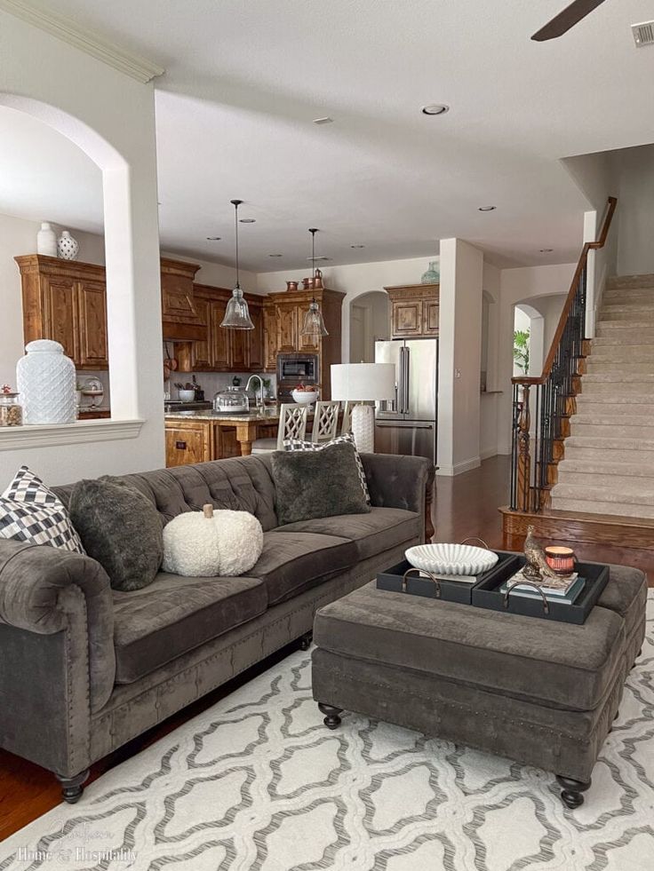 a living room filled with furniture and a stair case in front of the couches