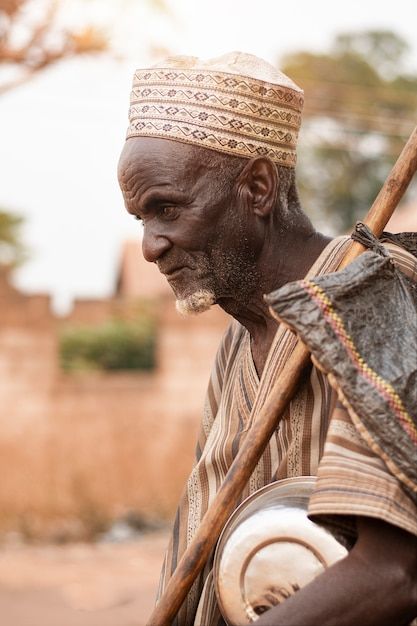 an african man with a stick and drum in his hand