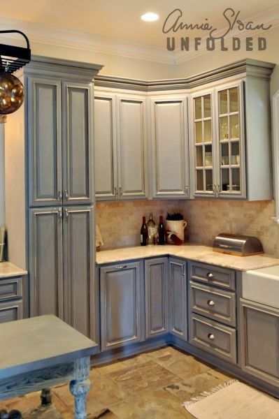 a kitchen with gray cabinets and white counter tops