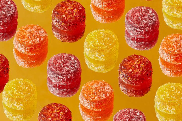 many different colored candies on a yellow background