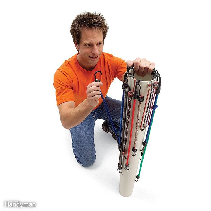 a man sitting on the ground holding an object with multiple wires and cords attached to it