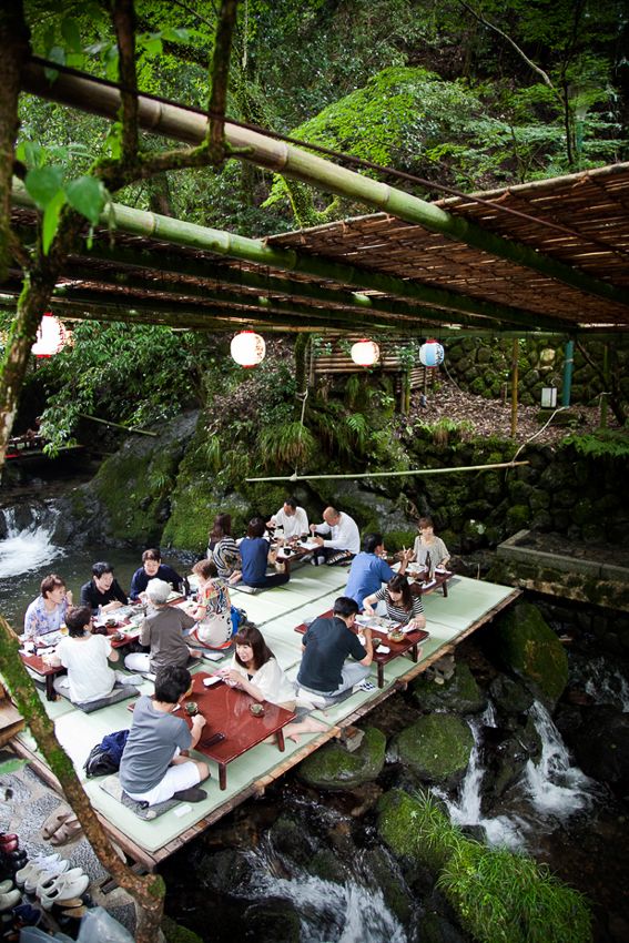 a group of people sitting on top of a raft in the middle of a river