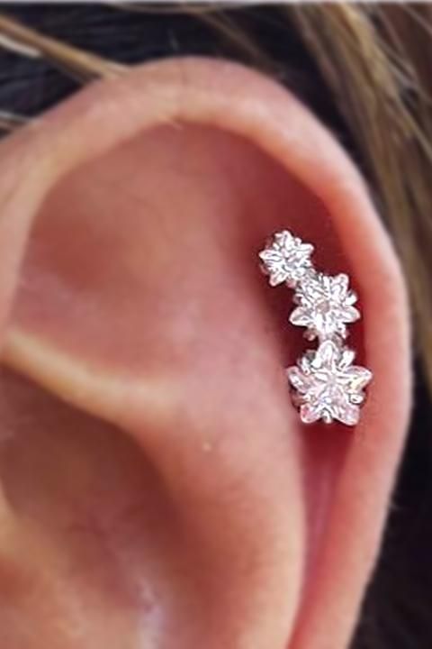 a woman's ear with three small flowers on it