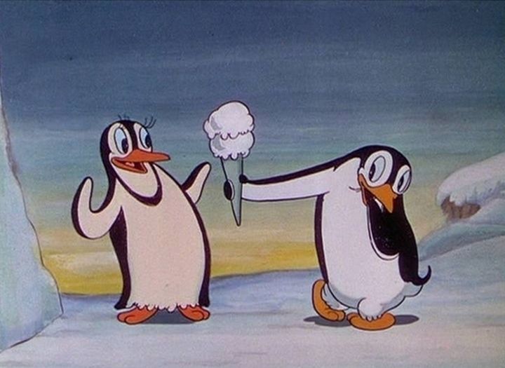 two penguins are standing in the snow and one penguin is holding something up to his face