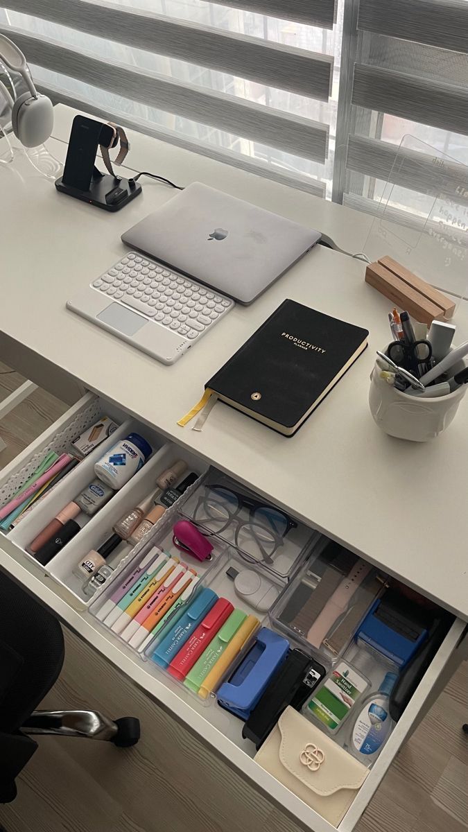 an office desk with many items on it, including a laptop computer and other office supplies