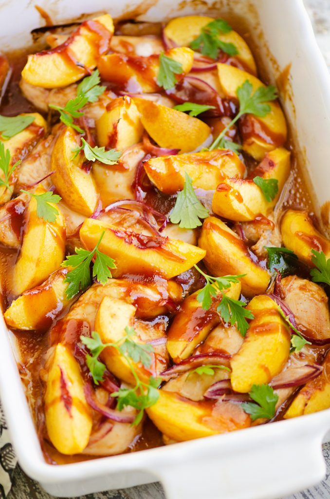 a casserole dish with meat and vegetables covered in sauce, garnished with parsley