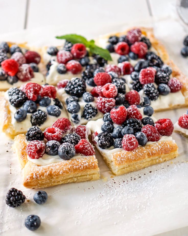 berries, blueberries and raspberries are arranged on top of puff pastry