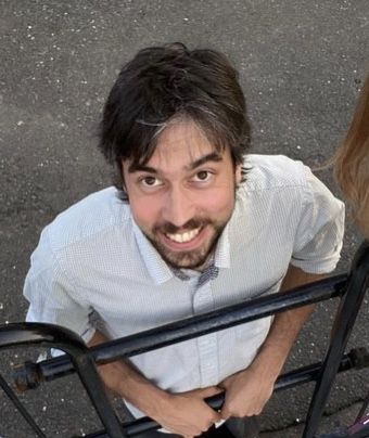 a man sitting on top of a metal bench next to a woman's head