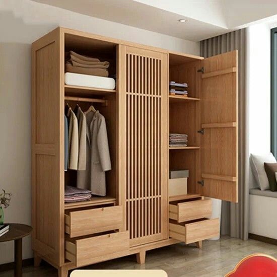 an open wooden wardrobe with clothes on it