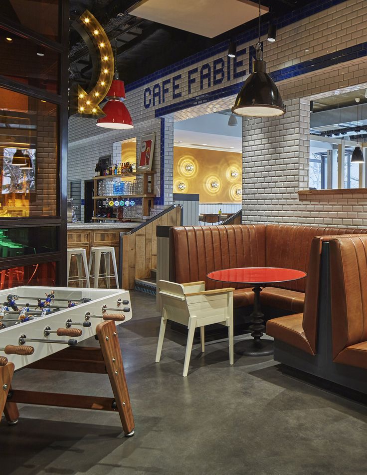 a room filled with lots of furniture next to a brick wall and a neon sign