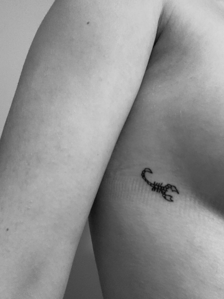 a black and white photo of a man's chest with a scorpion tattoo on it