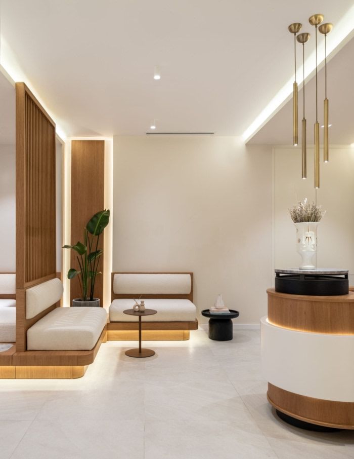 a modern living room with white walls and wood accents on the ceiling is lit by recessed lights