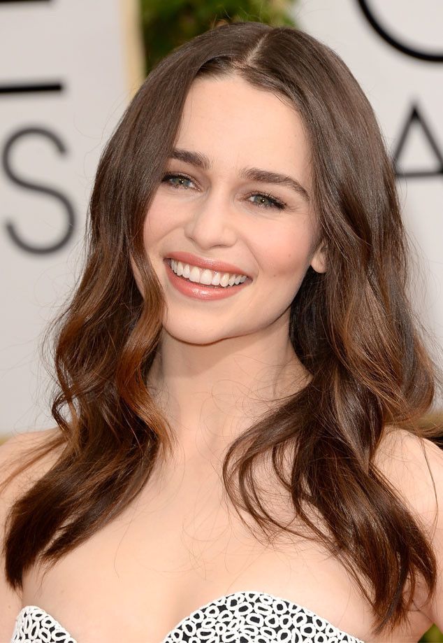 a close up of a person with long brown hair and a smile on her face