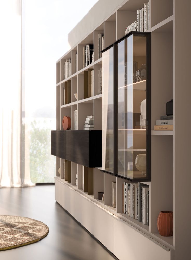 a living room with bookshelves and a rug on the floor in front of it